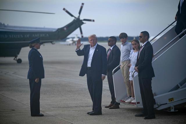 US President Donald Trump followed by his grandchildren Chloe and Spencer Trump step off Air Force One at Joint Base Andrews, Maryland on July 29, 2025. Trump returns to Washington following a trip to Scotland. (Photo by Brendan SMIALOWSKI / AFP)