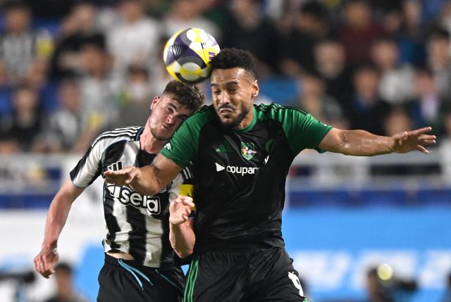 Newcastle United's Alex Murphy (L) fights for the ball with Team K-League's Mota (R) during the friendly football match between English Premier League football club Newcastle United and South Korean K League stars, Team K-League, in Suwon on July 30, 2025. (Photo by Jung Yeon-je / AFP)