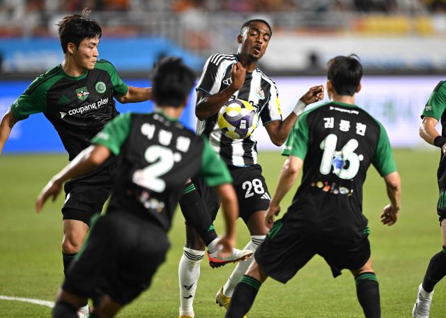 Newcastle United's Joe Willock (C) fights for the ball with Team K-League's Park Jin-seob (L) during the friendly football match between English Premier League football club Newcastle United and South Korean K League stars, Team K-League, in Suwon on July 30, 2025. (Photo by Jung Yeon-je / AFP)