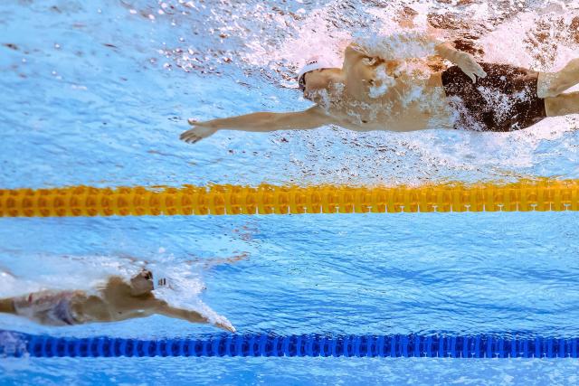 An underwater view shows US' swimmer Bobby Finke (R) and Hungary's swimmer David Betlehem as they comepte in  a heat of the men's 1500m freestyle swimming event during the 2025 World Aquatics Championships in Singapore on August 2, 2025. (Photo by Manan VATSYAYANA / AFP)