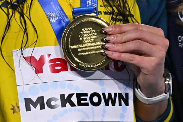 Australia's swimmer Kaylee McKeown holds her gold medal on the podium the women's 200m backstroke swimming event during the 2025 World Aquatics Championships in Singapore on August 2, 2025. (Photo by MANAN VATSYAYANA / AFP)
