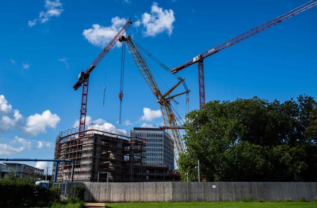 Cranes operate as work coninues on the extension of the Chancellery building in Berlin on August 4, 2025. Designed by Axel Schultes and Charlotte Frank, the architects also behind the current building, the expansion project includes a six-story, U-shaped building housing 400 offices, a heliport and several annex buildings. Everything is situated on a 60,000-square-meter site that is approximately the same size as the current Chancellery and is located on the other side of the Spree River. The cost of the planned extension is expected to reach EUR 777 million. (Photo by John MACDOUGALL / AFP)
