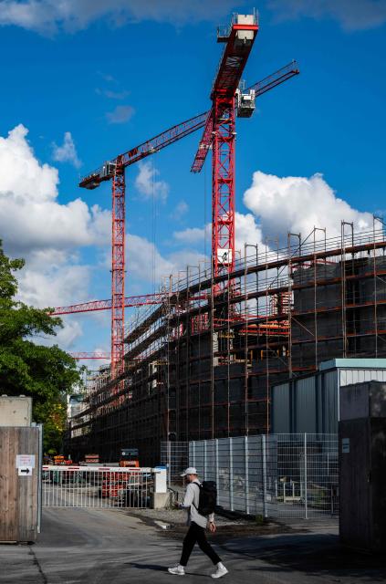 Cranes operate as work continues on the extension of the Chancellery building in Berlin on August 4, 2025. Designed by Axel Schultes and Charlotte Frank, the architects also behind the current building, the expansion project includes a six-story, U-shaped building housing 400 offices, a heliport and several annex buildings. Everything is situated on a 60,000-square-meter site that is approximately the same size as the current Chancellery and is located on the other side of the Spree River. The cost of the planned extension is expected to reach EUR 777 million. (Photo by John MACDOUGALL / AFP)