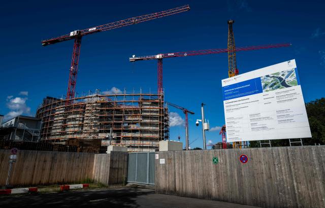 Cranes operate as work coninues on the extension of the Chancellery building in Berlin on August 4, 2025. Designed by Axel Schultes and Charlotte Frank, the architects also behind the current building, the expansion project includes a six-story, U-shaped building housing 400 offices, a heliport and several annex buildings. Everything is situated on a 60,000-square-meter site that is approximately the same size as the current Chancellery and is located on the other side of the Spree River. The cost of the planned extension is expected to reach EUR 777 million. (Photo by John MACDOUGALL / AFP)
