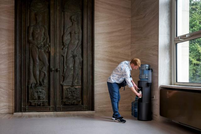 A delegates fill up his reusable water bottle next to the assembly hall at the start of plastics treaty negotiations at the United Nations Offices in Geneva on August 5, 2025. Countries were to start the clock on August 5, 2025, on 10 days of talks aimed at hammering out a landmark global treaty on combating the scourge of plastic pollution. Three years of negotiations hit the wall in South Korea in December 2024 when a group of oil-producing states blocked a consensus. (Photo by Fabrice COFFRINI / AFP)
