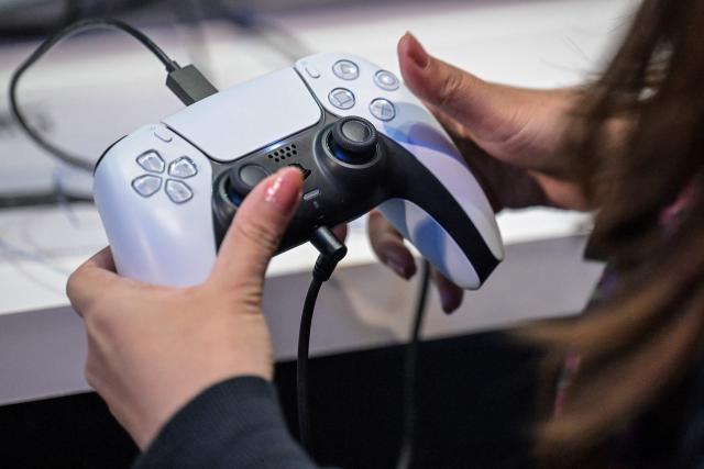 (FILES) This file photo taken on September 26, 2024 shows a member of the media trying out Sony's new PlayStation 5 console during the preview day for the annual Tokyo Game Show at Makuhari Messe in Chiba City, Chiba Prefecture. Japan's Sony raised its net profit forecast for the current financial year to 970 billion yen (6.6 billion USD) on August 7, 2025, up from the previous estimate of 930 billion yen. (Photo by Richard A. Brooks / AFP)