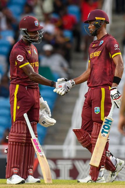 Justin Greaves (L) and Roston Chase (R) of West Indies celebrate winning the second One Day International (ODI) cricket match between West Indies and Pakistan at Brian Lara Cricket Academy in Tarouba, San Fernando, Trinidad and Tobago on August 10, 2025. (Photo by Randy Brooks / AFP)