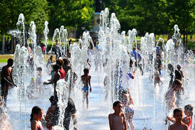 (FILES) Children refresh themselves at a fountain in Reims, northern France, on July 1, 2025 as a heatwave hits France. The red heat alert remains in force until August 13 in the 14 departments of the South-West and the Centre-East concerned, Meteo-France announced in its latest bulletin, on August 12, 2025. (Photo by FRANCOIS NASCIMBENI / AFP)