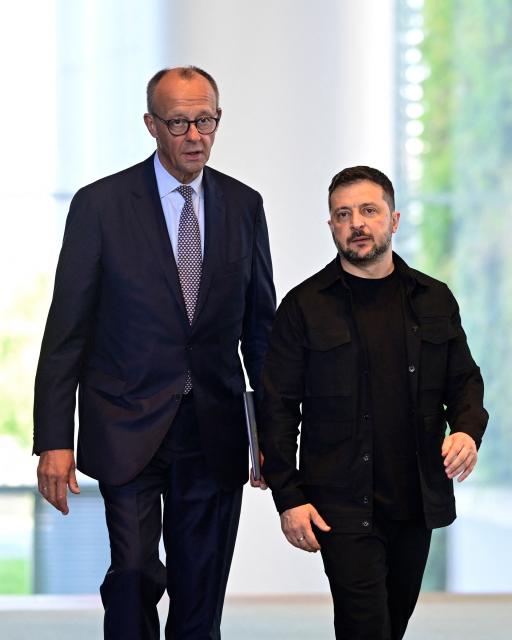 Ukrainian President Volodymyr Zelensky (R) and German Chancellor Friedrich Merz arrive to address a joint press conference after a video conference of European leaders with the US President on the Ukraine war ahead of a summit between the US and Russian leaders, in Berlin, on August 13, 2025. European leaders held online talks with US President Trump, hoping to convince him to respect Ukraine's interests when he discusses the war with Putin in Alaska on August 15. (Photo by John MACDOUGALL / AFP)