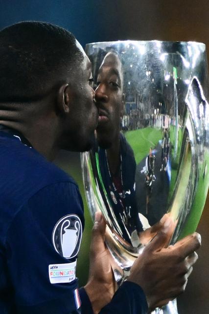 Paris Saint-Germain's French forward #10 Ousmane Dembele kisses the trophy as he celebrates winning the 2025 UEFA Super Cup final football match between Paris Saint-Germain (FRA) and Tottenham Hotspur FC (ENG) at the Friuli stadium, in Udine, on August 13, 2025. (Photo by Marco BERTORELLO / AFP)