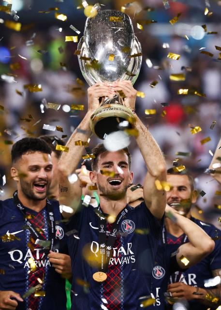 Paris Saint-Germain's Spanish midfielder #08 Fabian Ruiz lifts the trophy as Paris Saint-Germain celebrate winning the 2025 UEFA Super Cup final football match between Paris Saint-Germain (FRA) and Tottenham Hotspur FC (ENG) at the Friuli stadium, in Udine, on August 13, 2025. (Photo by FRANCK FIFE / AFP)