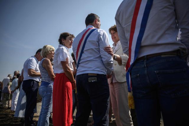 Agriculture minister Annie Genevard (centre R) greets local winegrowers as she visits a vineyard affected by a recent forest fire, in Saint-Laurent-de-la-Cabrerisse, southwestern France on August 14, 2025. (Photo by Ed JONES / AFP)