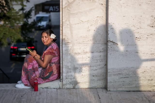 An activist waits outside the assembly hall on the final day of negotiations of a landmark global treaty on plastic pollution, at the United Nations Offices in Geneva on August 14, 2025. Negotiators trying to secure a global agreement on tackling the scourge of plastic pollution were frantically trying to find common ground with just hours left. (Photo by Fabrice COFFRINI / AFP)