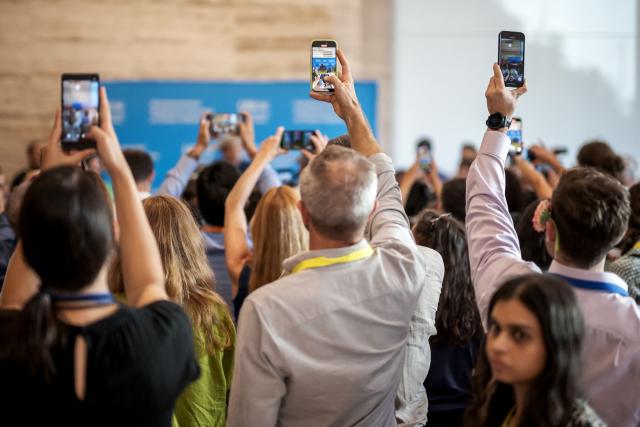 Activits and members of the civil society record with their mobile an action outside the assembly hall on the final day of negotiations of a landmark global treaty on plastic pollution, at the United Nations Offices in Geneva on August 14, 2025. Negotiators trying to secure a global agreement on tackling the scourge of plastic pollution were frantically trying to find common ground with just hours left, on August 14, 2025. (Photo by Fabrice COFFRINI / AFP)