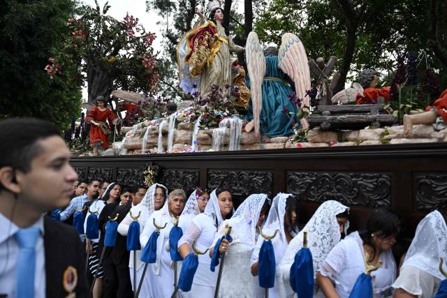 Catholic faithful carry the image of the Virgin of the Assumption as they take part in a parade to celebrate the day of the city's patron saint in Guatemala City on August 15, 2025. (Photo by JOHAN ORDONEZ / AFP)
