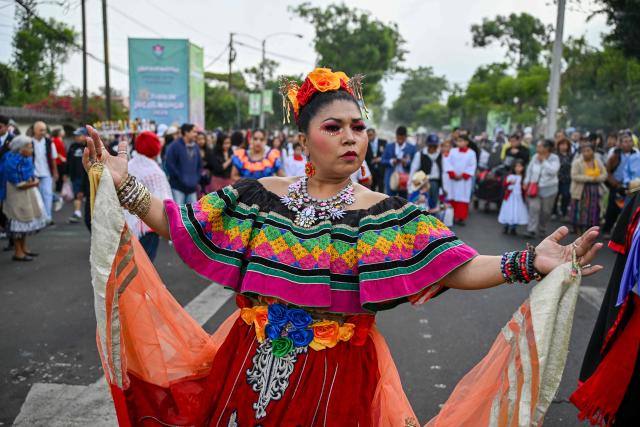A Catholic faithful dances as she takes part in a parade to celebrate the day of the Virgin of the Assumption, the city's patron saint, in Guatemala City on August 15, 2025. (Photo by JOHAN ORDONEZ / AFP)