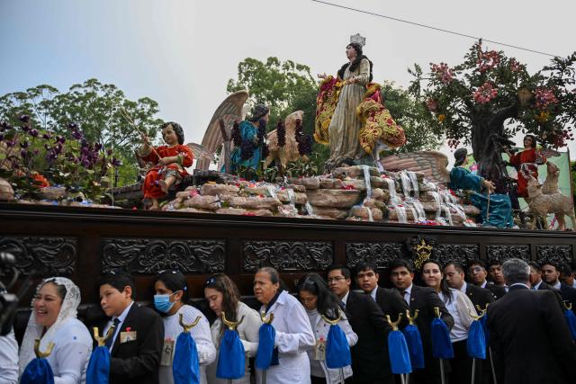 Catholic faithful carry the image of the Virgin of the Assumption as they take part in a parade to celebrate the day of the city's patron saint in Guatemala City on August 15, 2025. (Photo by JOHAN ORDONEZ / AFP)
