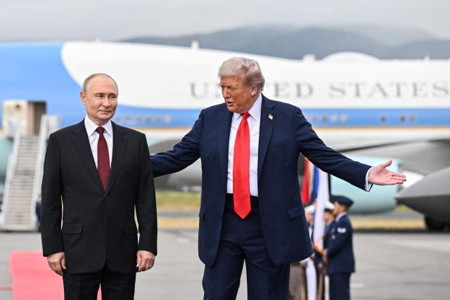 In this pool photograph distributed by the Russian state agency Sputnik, US President Donald Trump and Russian President Vladimir Putin pose for photos during a US-Russia summit on Ukraine at Joint Base Elmendorf-Richardson in Anchorage, Alaska, on August 15, 2025. (Photo by Sergey Bobylev / POOL / AFP)