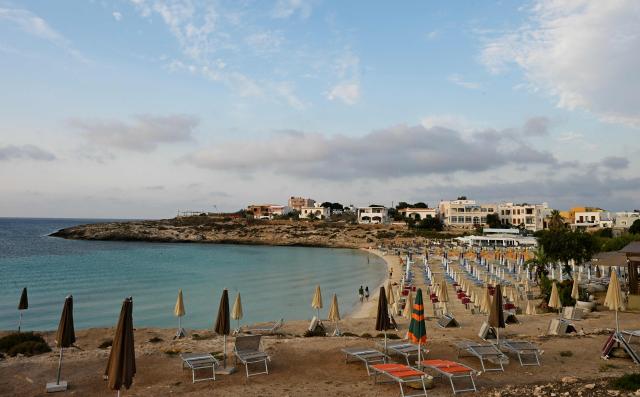 Deckchairs and closed umbrellas are displayed on a beach in Lampedusa, south Italy, on August 16, 2025. (Photo by Stefano RELLANDINI / AFP)