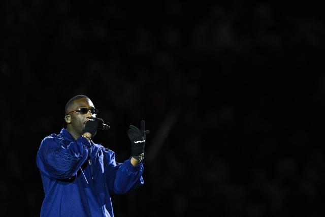 (FILES) French rap singer SDM performs ahead of the French L1 football match between Paris Saint-Germain (PSG) and Olympique de Marseille (OM) at the Parc des Princes Stadium in Paris, on March 16, 2025. SDM, who proudly displays his Congolese roots and his love for PSG, is riding high in the charts at 29 years old with three albums, featuring a range of hits such as 'Bolide allemand' and 'Dolce Camara' with Booba. His concerts, like the one at Cabaret Vert where AFP met him on August 15, 2025, feel like fiery communions with his audience. (Photo by JULIEN DE ROSA / AFP)