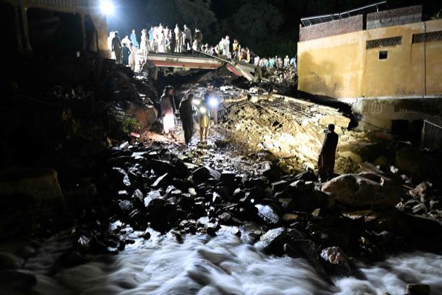Rescue workers and residents search for victims in the debris of collapsed houses after a cloudburst in Dolari village, Swabi district, in northern Pakistan's mountainous Khyber Pakhtunkhwa province, on August 18, 2025. Fresh torrential rains in northern Pakistan killed at least 20 people on August 18, local officials said, as the region is ravaged by an unusually intense monsoon season that has left more than 300 people dead in recent days. (Photo by Aamir QURESHI / AFP)