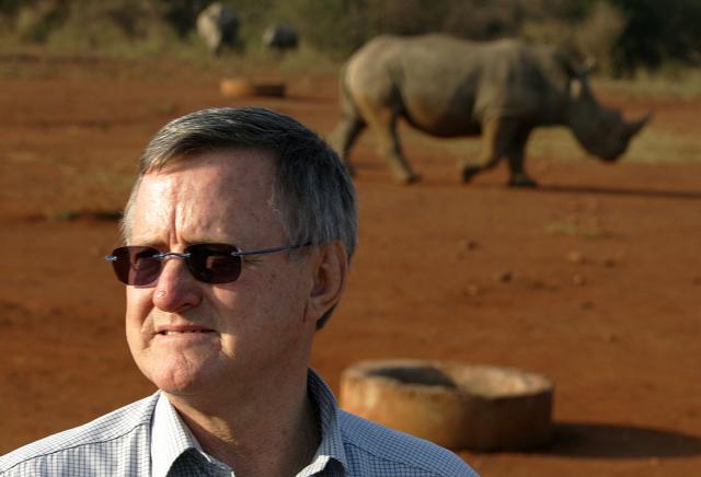 (FILES) Zimbabwe-born, multi-millionaire game farmer John Hume poses September 30, 2004 in front of a black male rhinoceros outside the northeastern town of Malelane, next to Kruger National Park. The former owner of a huge South African rhino conservation farm was arrested Tuesday on charges of smuggling the horns of the endangered animals, police said. 
John Hume was arrested alongside five others following a seven-year "complex investigation into transnational trafficking of rhino horns", the police's specialised Hawks unit said. (Photo by ALEXANDER JOE / AFP)