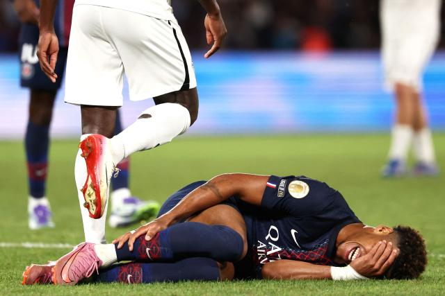 Paris Saint-Germain's French midfielder #14 Desire Doue lies on the football pitch after a fool during the French L1 football match between Paris Saint-Germain (PSG) and Angers SCO at the Parc des Princes Stadium in Paris on August 22, 2025. (Photo by FRANCK FIFE / AFP)