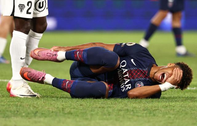 Paris Saint-Germain's French midfielder #14 Desire Doue lies on the football pitch after a foul during the French L1 football match between Paris Saint-Germain (PSG) and Angers SCO at the Parc des Princes Stadium in Paris on August 22, 2025. (Photo by FRANCK FIFE / AFP)