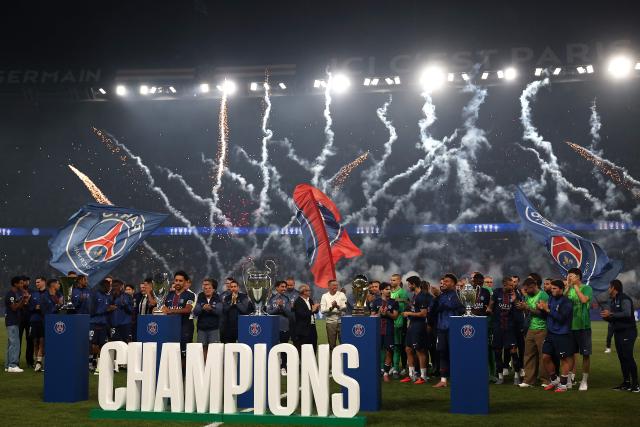 TOPSHOT - PSG's players and staffs pose with their trophies for the 2024–2025 season (Ligue 1, Coupe de France, Trophйe des Champions, the UEFA Champions League) and the UEFA Super Cup trophy, after the French L1 football match between Paris Saint-Germain (PSG) and Angers SCO at the Parc des Princes Stadium in Paris on August 22, 2025. (Photo by FRANCK FIFE / AFP)