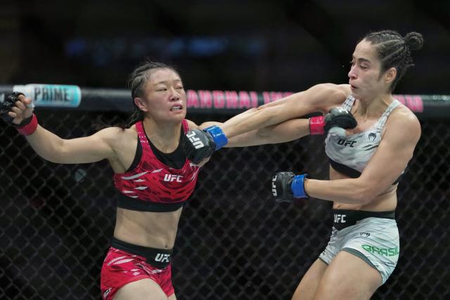 China's Shi Ming (L) fights against Brazil's Bruna Brasil during their women's Strawweight event of the UFC Fight Night in Shanghai on August 22, 2025. (Photo by -STR / AFP) / China OUT