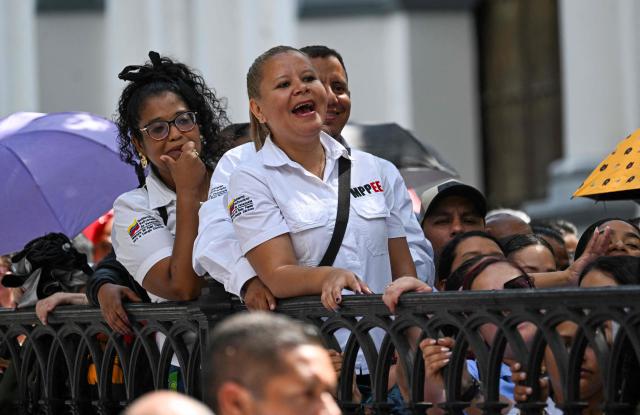 People line up during the Bolivarian militia enlistment process at Bolivar square in Caracas on August 23, 2025. Thousands of people enlisted in Venezuela's military forces on Saturday to join the ranks in preparation for a possible US invasion. (Photo by Juan BARRETO / AFP)