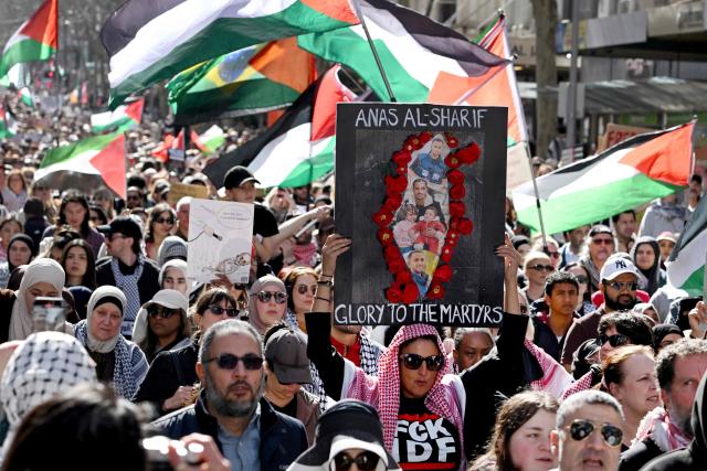 A demonstrator holds a placard in honour of Al Jazeera journalist Anas al-Sharif, who was killed by an Israeli strike in Gaza, during a pro-Palestinian rally against Israel's actions and ongoing food shortages in the Gaza Strip, which the UN officially declared a famine on August 22, during a protest in Melbourne on August 24, 2025. (Photo by William WEST / AFP)