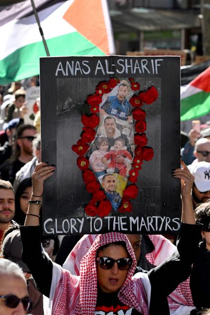 A demonstrator holds a placard in honour of Al Jazeera journalist Anas al-Sharif, who was killed by an Israeli strike in Gaza, during a pro-Palestinian rally against Israel's actions and ongoing food shortages in the Gaza Strip, which the UN officially declared a famine on August 22, during a protest in Melbourne on August 24, 2025. (Photo by William WEST / AFP)