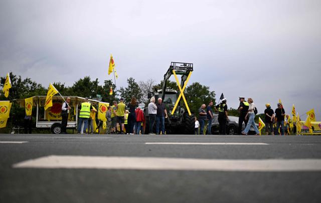 Demonstrators protest against the Castor transports in front of the Ahaus interim storage facility in Ahaus, western Germany on August 26, 2025. On August 26, 2025, the Federal Office for the Safety of Nuclear Waste Disposal (BASE) approved the controversial transport of nuclear waste from Juelich in the Rhineland to the interim storage facility in Ahaus in the Münsterland region. Spontaneous protests have now been announced in Juelich and Ahaus. (Photo by Ina FASSBENDER / AFP)