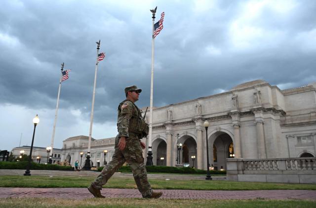 (FILES) Members of the DC National Guard patrol outside Union Station as a storm approaches in Washington, DC, on August 17, 2025. According to US media reports on August 27, the US Department of Transportation is planning to take over management of Union Station in Washington, DC. (Photo by Andrew Caballero-Reynolds / AFP)