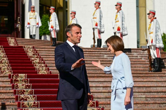 Moldova's President Maia Sandu (R) welcomes France's President Emmanuel Macron in Chisinau on August 27, 2025, during Moldova's 34th Independence Day celebrations. The leaders of France, Germany and Poland arrive in Moldova in a show of support, a day before campaigning starts for next month's tense parliamentary election amid claims of Russian interference in the pro-EU nation bordering Ukraine. (Photo by Daniel MIHAILESCU / AFP)