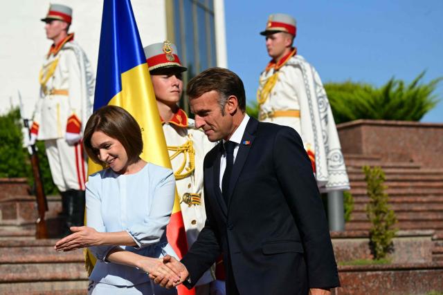 Moldova's President Maia Sandu (L) welcomes France's President Emmanuel Macron in Chisinau on August 27, 2025, during Moldova's 34th Independence Day celebrations. The leaders of France, Germany and Poland arrive in Moldova in a show of support, a day before campaigning starts for next month's tense parliamentary election amid claims of Russian interference in the pro-EU nation bordering Ukraine. (Photo by Daniel MIHAILESCU / AFP)