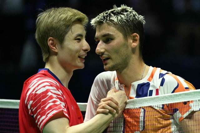 China's Shi Yu Qi (L) is congratulated by France's Christo Popov at the end of their men's single match at the Badminton BWF World Championships at the Adidas Arena in Paris, on August 28, 2025. (Photo by Bertrand GUAY / AFP)