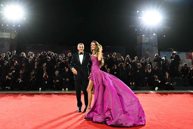 TOPSHOT - US actor George Clooney and his wife Amal Clooney walk the red carpet before the screening of the movie "Jay Kelly" presented in competition at the 82nd International Venice Film Festival, at Venice Lido on August 28, 2025. (Photo by Stefano RELLANDINI / AFP)