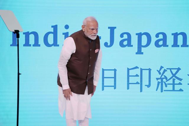 India's Prime Minister Narendra Modi bows before delivering a speech at the Japan-India Economic Forum in Tokyo on August 29, 2025. (Photo by Kazuhiro NOGI / AFP)