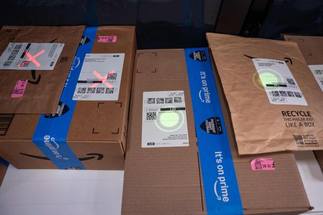 (FILES) Vision-Assisted Package Retrieval (VAPR) scans packages at Amazon's electric delivery vehicle during the Amazon "Delivering the Future" conference at Amazon’s advanced fulfillment center in Mt. Juliet, Tennessee, on October 9, 2024. The United States on August 29, 2025 ended tariff exemptions on small packages entering the country from abroad, in a move that has sparked concern among small businesses and warnings of consumer price hikes. (Photo by SETH HERALD / AFP)