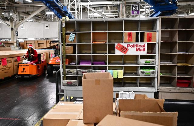 (FILES) This photo taken on November 30, 2023 shows postal workers wearing Santa hats during a media tour hosted by the US Postal Service at the Los Angeles Processing and Distribution Center, the largest in the country, equivalent to 29 football fields. The United States on August 29, 2025 ended tariff exemptions on small packages entering the country from abroad, in a move that has sparked concern among small businesses and warnings of consumer price hikes. (Photo by Frederic J. BROWN / AFP)