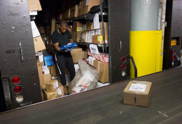 (FILES) UPS employees sort out packages before loading them onto delivery trucks on May 9, 2017 at the Manhattan UPS facility in New York. The United States on August 29, 2025 ended tariff exemptions on small packages entering the country from abroad, in a move that has sparked concern among small businesses and warnings of consumer price hikes. (Photo by Don EMMERT / AFP)