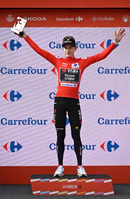 The overall leader Team Visma-Lease a bike's Danish rider Jonas Vingegaard celebrates on the podium wearing the red jersey after the tenth stage of the Vuelta a Espana cycling tour, a 168 km race between Sendaviva Natural Park in Arguedas and El Ferial Larra Belagua in Isaba, on September 2, 2025. (Photo by Ander GILLENEA / AFP)
