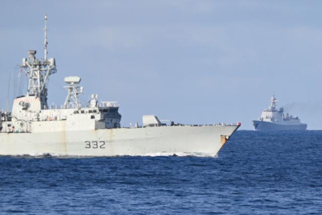 A Chinese PLA Navy ship (background R) shadows the Royal Canadian Navy frigate HMCS Ville de Quebec (L) during a maritime cooperative activity between the Philippines, Australia and Canadian navies near Scarborough Shoal in disputed waters of the South China Sea on September 3, 2025. (Photo by Ted ALJIBE / AFP)