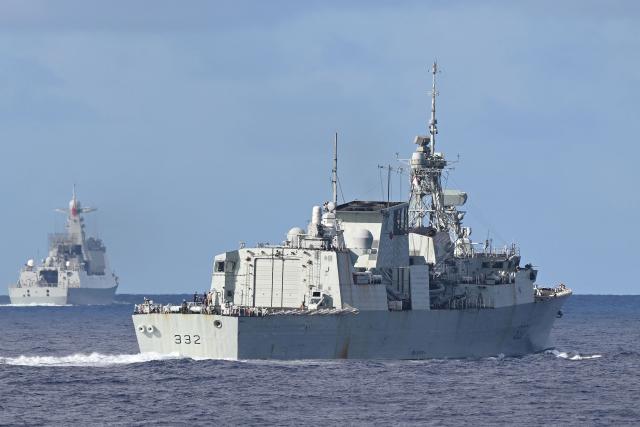 The Royal Canadian Navy frigate HMCS Ville de Quebec (R) is seen in front of a monitoring Chinese PLA Navy vessel (L) during a maritime cooperative activity between the Philippines, Australia and Canadian navies near Scarborough Shoal in disputed waters of the South China Sea on September 3, 2025. (Photo by Ted ALJIBE / AFP)