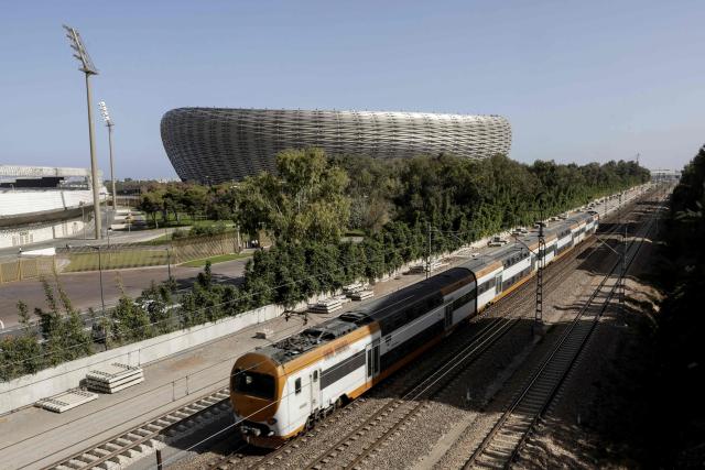 A train drives past the Prince Moulay Abdellah Stadium in Rabat, which was completely demolished in 2023 and rebuilt according to the latest international standards, in Rabat, on September 5, 2025, ahead of the FIFA World Cup 2026 Group E African qualification football match between Morocco and Niger. The stadium built in preparation for two major events: the 2025 Africa Cup of Nations and the 2030 FIFA World Cup, co-hosted by Morocco, Spain, and Portugal. (Photo by Abdel Majid BZIOUAT / AFP)