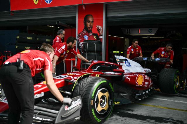 Ferrari team mechanics examine Ferrari's British driver Lewis Hamilton's car in the pit lane before the first practice session ahead of the Italian Formula One Grand Prix at the Autodromo Nazionale Monza circuit, in Monza, northern Italy, on September 5, 2025. (Photo by Marco BERTORELLO / AFP)