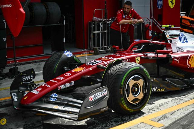 A Ferrari team member looks on by Ferrari's British driver Lewis Hamilton's car in the pit lane before the first practice session ahead of the Italian Formula One Grand Prix at the Autodromo Nazionale Monza circuit, in Monza, northern Italy, on September 5, 2025. (Photo by Marco BERTORELLO / AFP)