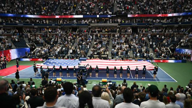 A large US flag is unfurled during the men's singles final tennis match between Italy’s Jannik Sinner and Spain’s Carlos Alcaraz on day fifteen of the US Open tennis tournament at the USTA Billie Jean King National Tennis Center in New York City, on September 7, 2025. (Photo by Mandel NGAN / AFP)